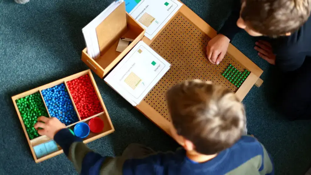 Gruppe von Kindern präsentiert ein langes Sauriermodell im Unterricht.