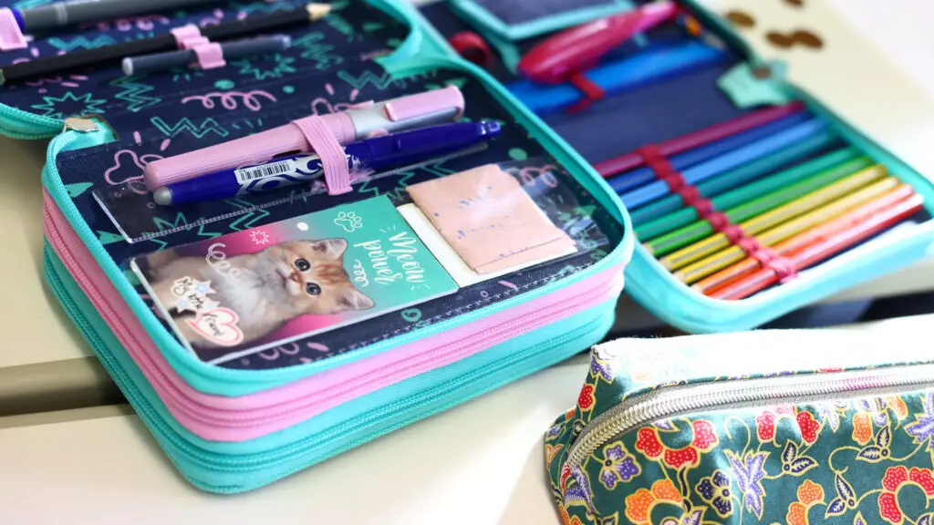Offene Federmäppchen und Stifteboxen im bunten Kinderhaus-Alltag.